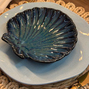 Unidade do conjunto de pratos ocean sobre um prato azul da linha Blue Bay em uma mesa posta