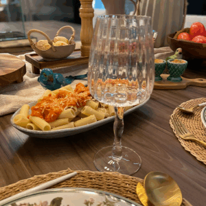 Taça transparente sobre uma mesa posta.