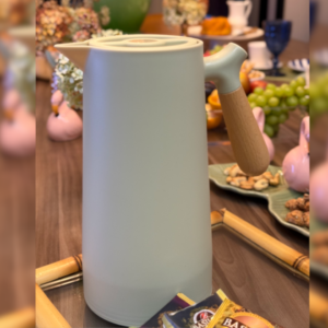 Garrafa Térmica Verde com cabo de madeira em uma mesa posta