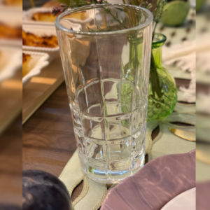 Unidade do conjunto de 6 copos de vidro em uma mesa posta.